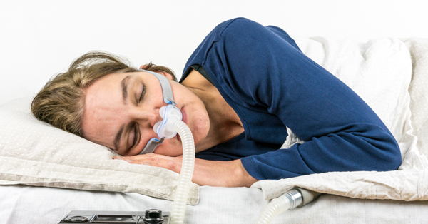 a woman sleeping with a CPAP mask