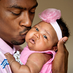 Father kissing daughter on cheek.