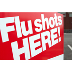 A sign advertises flu vaccines, with the words 'Flu Shots HERE!'