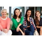 Four women sitting on the steps in front of an office building