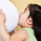 Young girl kissing her pregnant mother’s stomach.