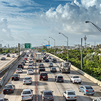 A busy highway with highrise buildings on the horizon.