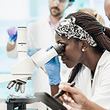 Scientist looking into a microscope.