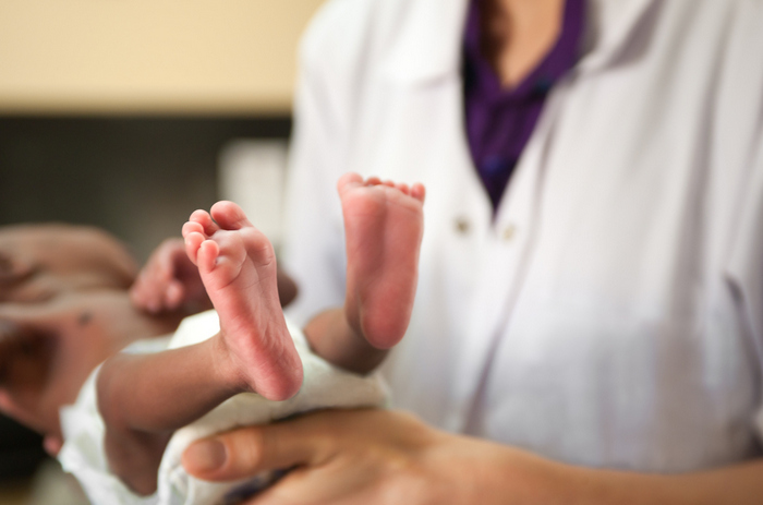 A healthcare worker holding a newborn.