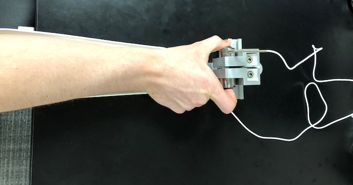 A hand holding the device used to measure grip strength.