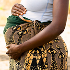 A pregnant woman with hands on her abdomen