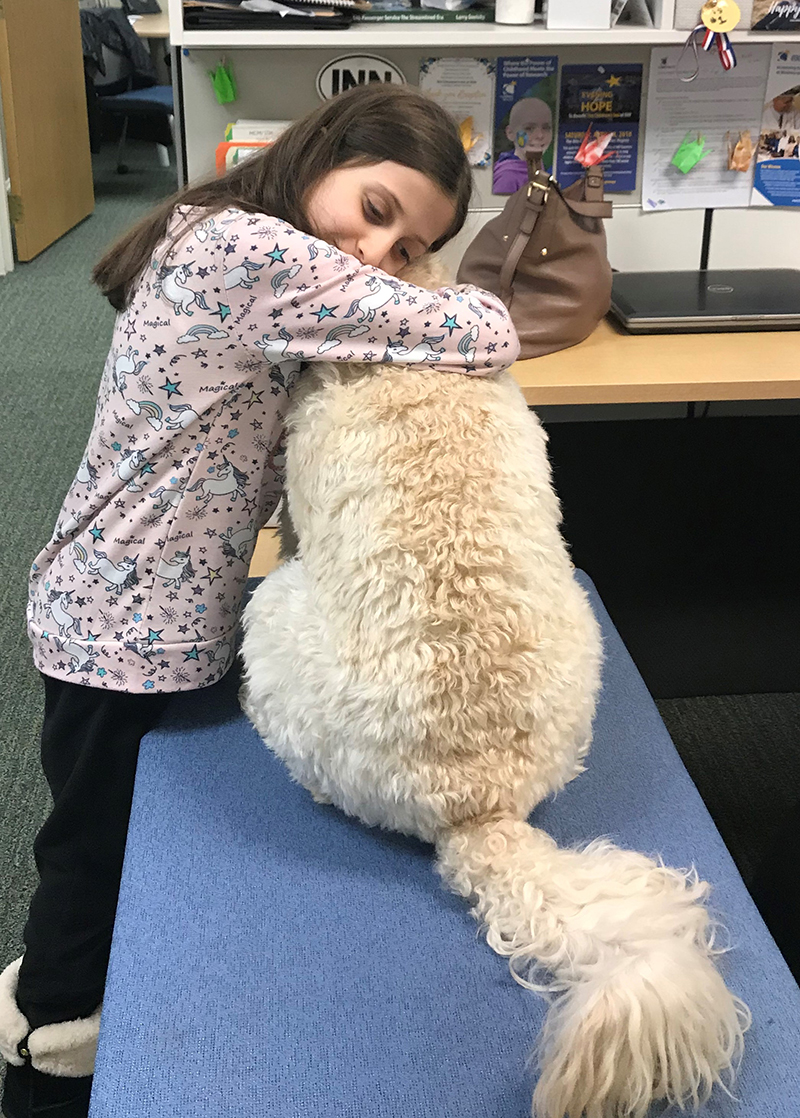 Girl hugs dog.