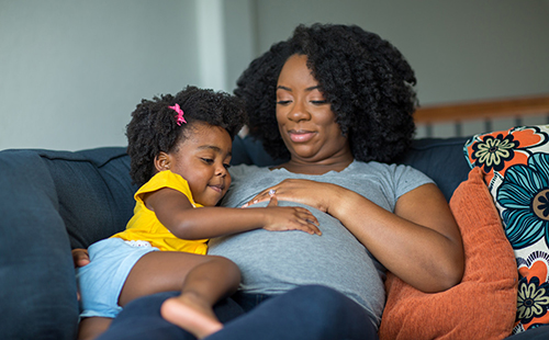 African American pregnant mother and her daughter.