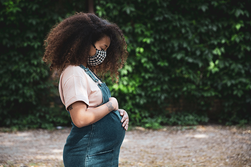 Pregnant woman standing and thinking.