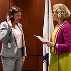 Dr. Cernich raises her right hand while Dr. Diana W. Bianchi, NICHD Director, reads from a piece of paper.