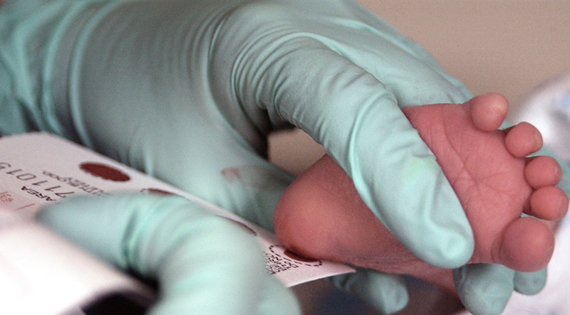 Blood sample being taken from a newborn’s heel for screening.