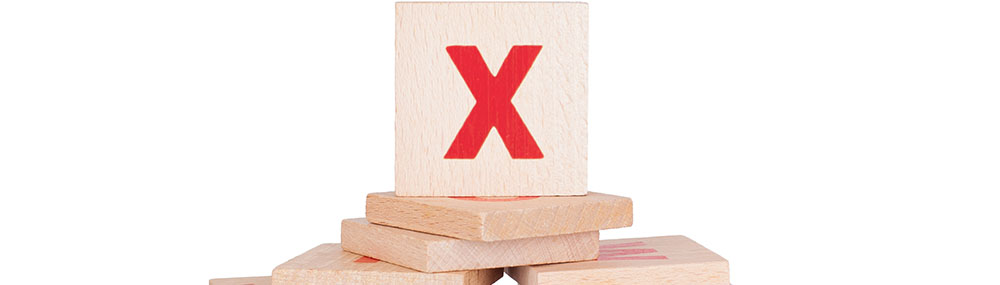 Letter tile painted with a large red “X” on it. 