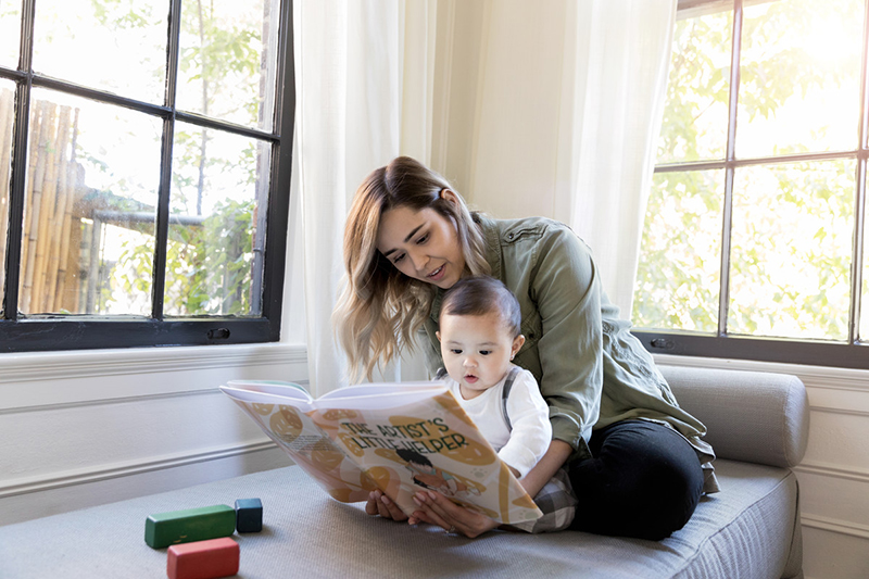 Parent and child looking at a picture book together.