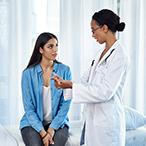 A woman speaks with her healthcare provider during a checkup.