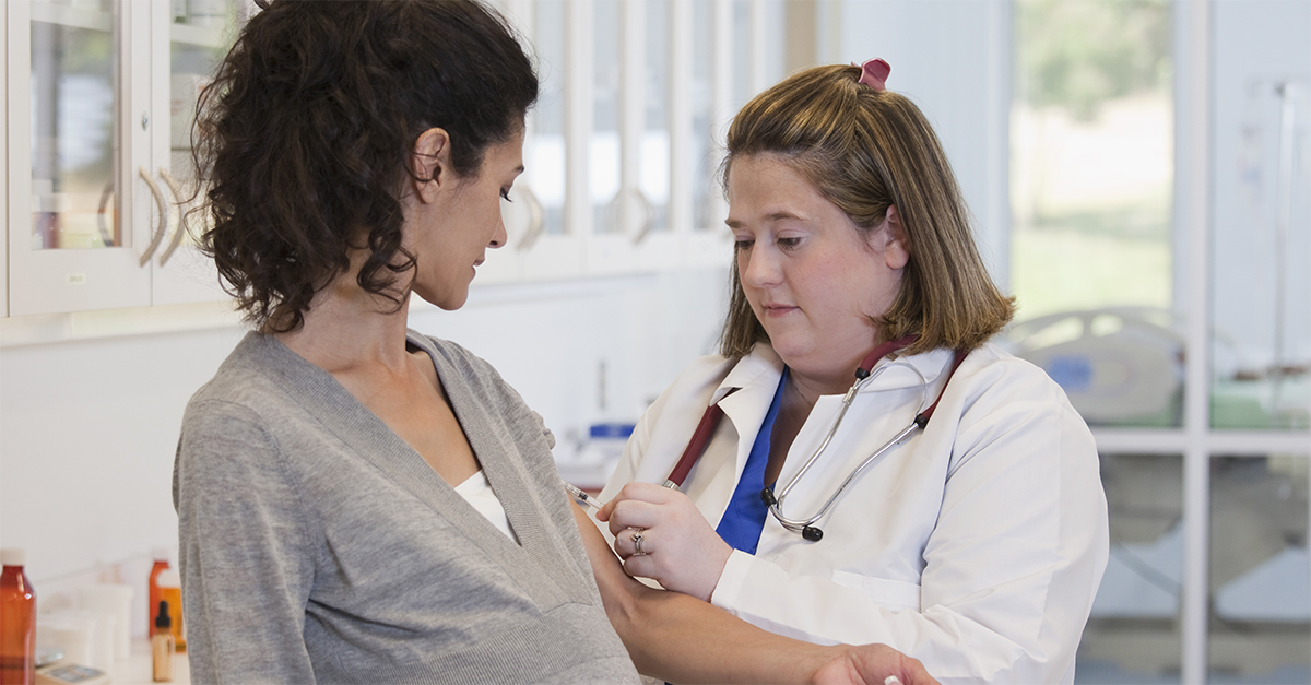 A health care provider takes blood from the inner arm of a pregnant person.