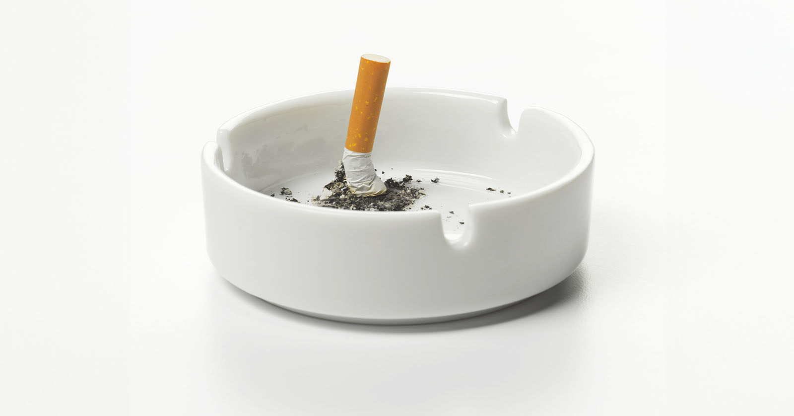 A crushed cigarette butt in an ashtray.