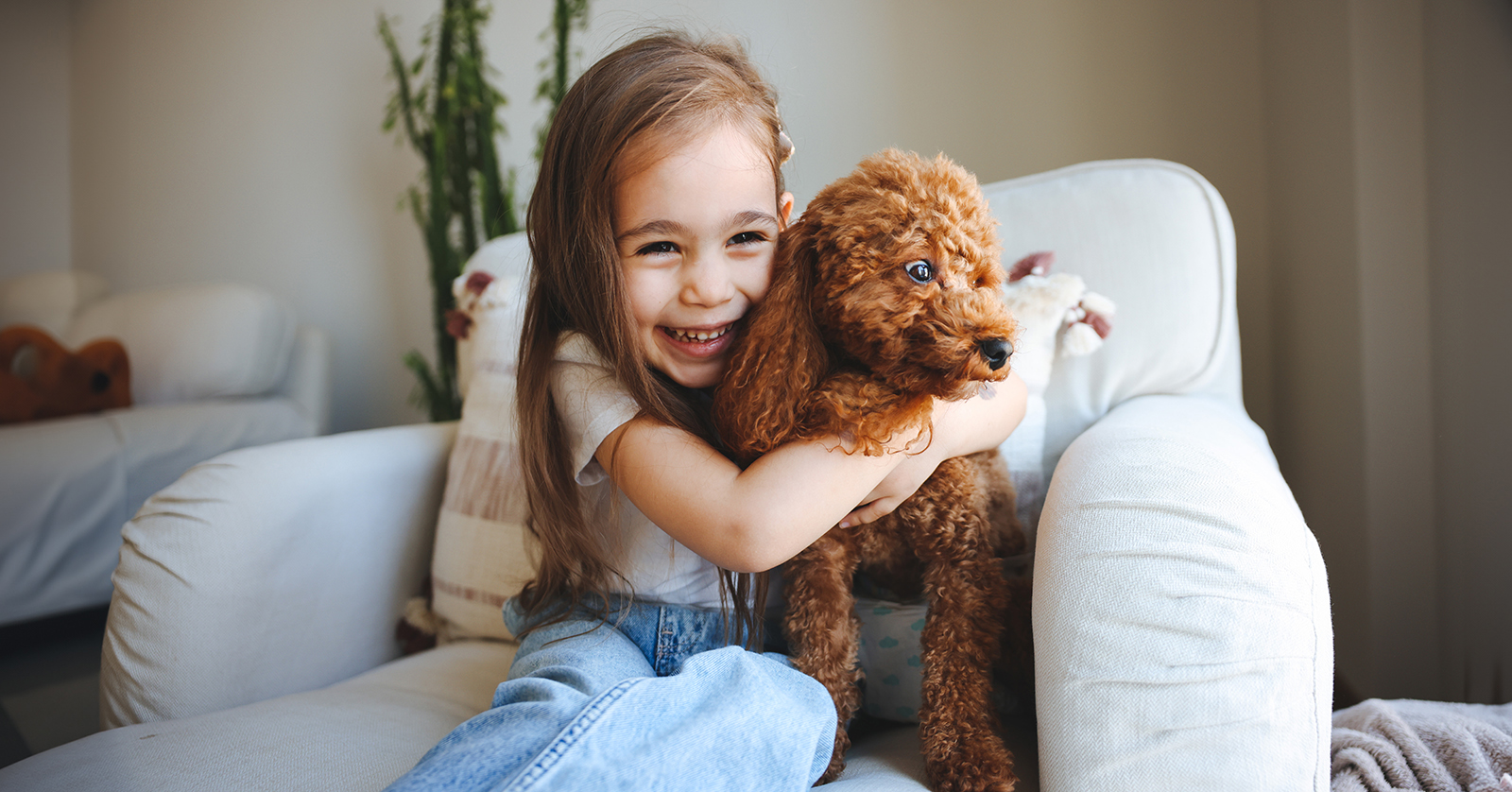 Smiling child hugging small dog.