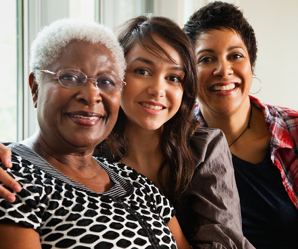 Image of 3 smiling women who are from different generations within a family. 