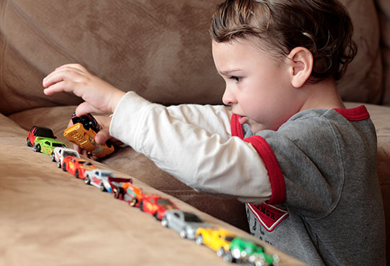 Stock image of a boy playing with toy cars