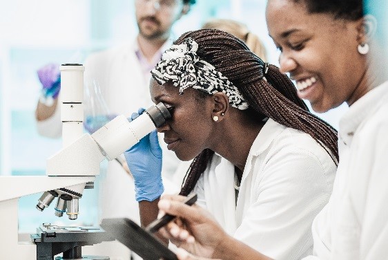 Woman looking into a microscope.