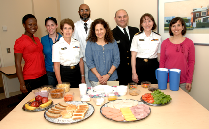 Group photo in front on table full of food used in experiments.