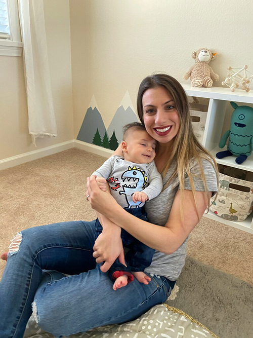 Woman sitting on floor holding baby.