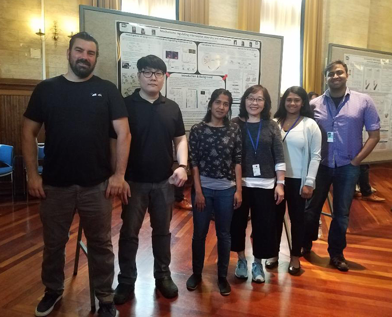 Group photo of the lab in front of BSC poster in June 2019.