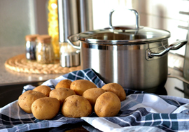 Potatoes next to cooking pot.